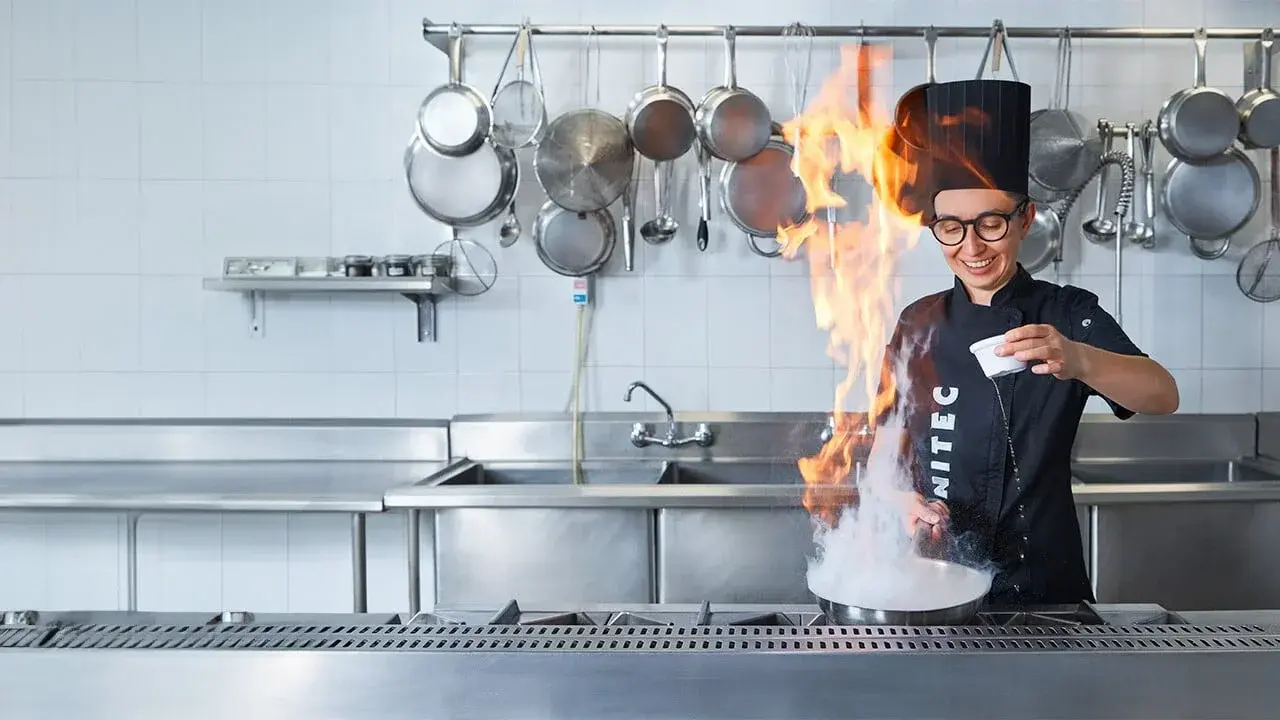 Profesora chef de la escuela de gastronomía, realizando una práctica de preparación alimentos