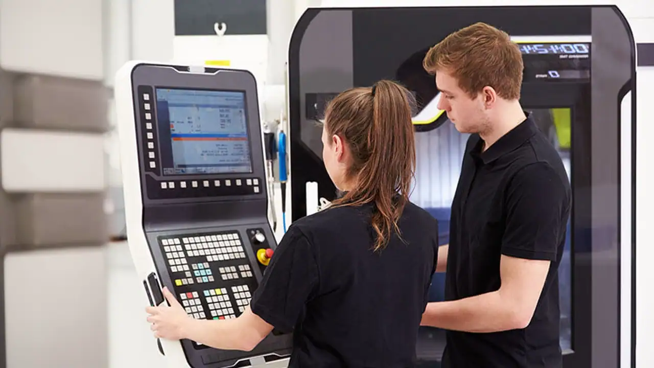 Estudiantes ingeniero industriales operando una máquina de Control Numérico Computarizado (CNC)..