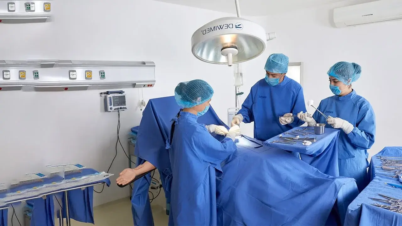 Estudiantes de escuela de medicina en UNITEC haciendo una práctica de cirujía en hospital simulado
