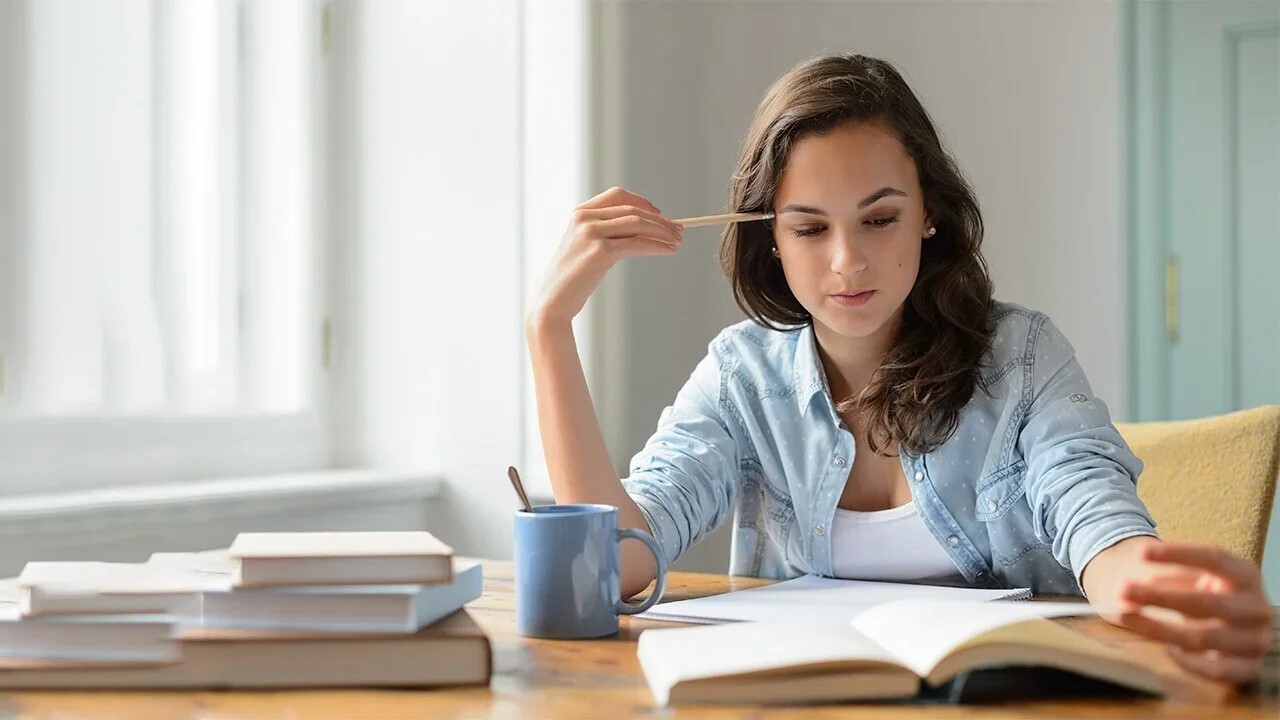 Alumna de la carrera en psicología UNITEC estudiando sus anotaciones