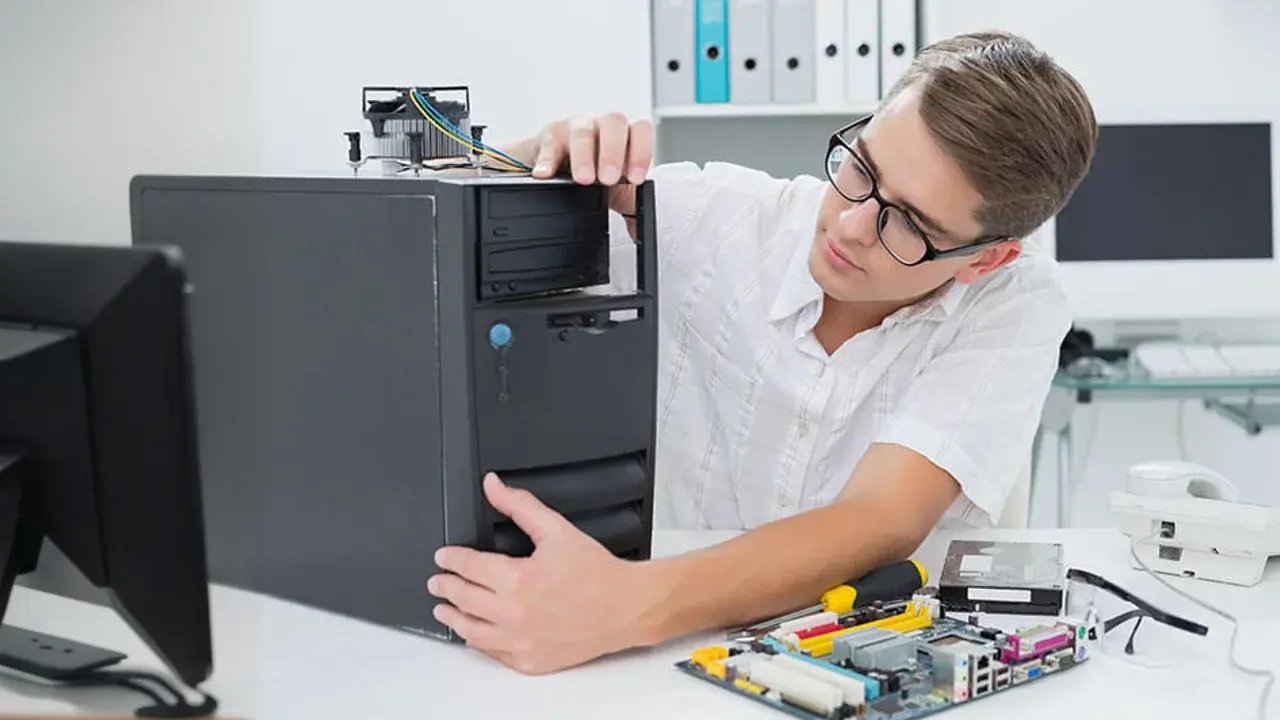 Estudiante de ingeniería de sistemas computacionales inspeccionando equipo de cómputo.