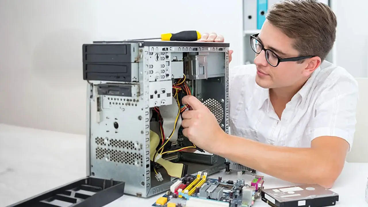 Alumno de ingeniería de sistemas y computación reparando una computadora.