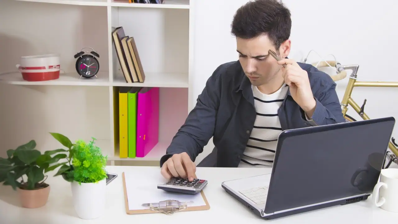 Alumno de la carrera en finanzas realiza su tarea con una calculadora.