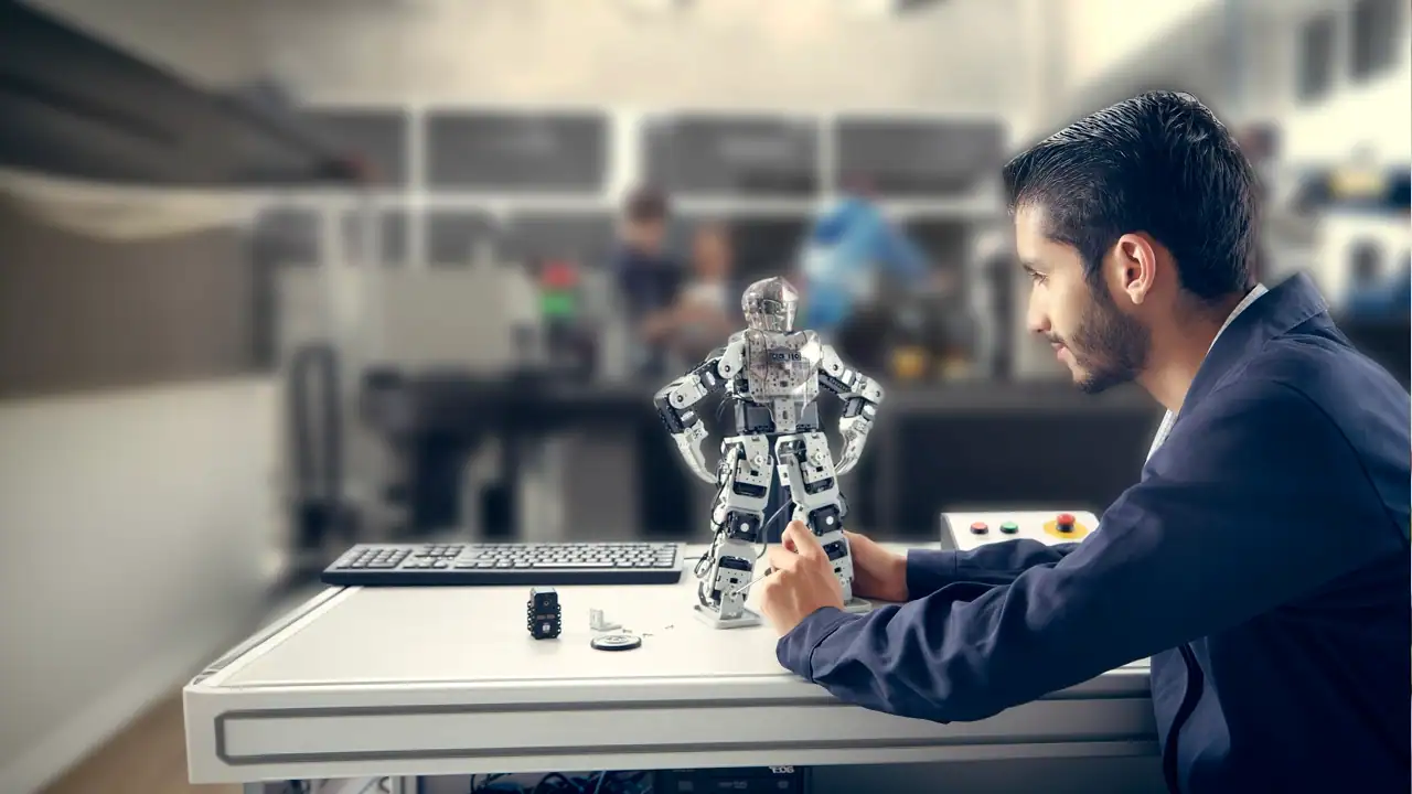 Alumno de UNITEC de la ingeniería en robótica trabaja con un mini robot en clase.