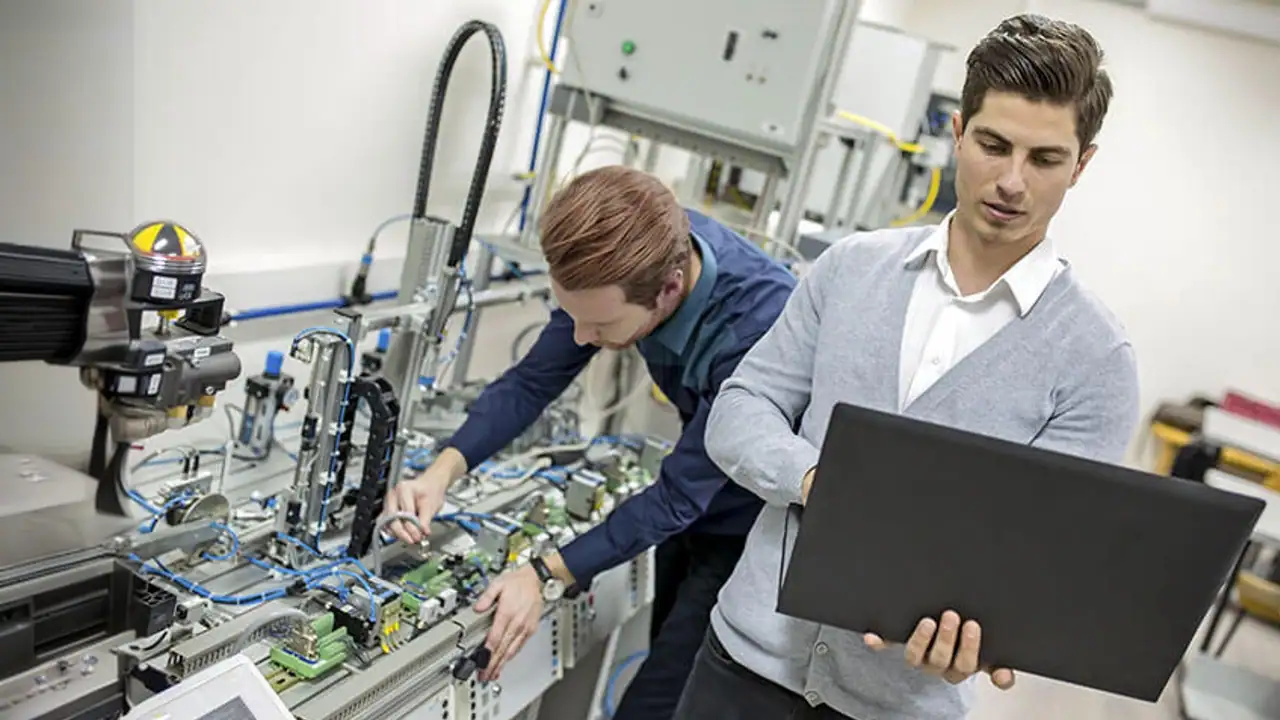 Dos profesionales de la carrera de Robótica colaboran en un proyecto tecnológico.