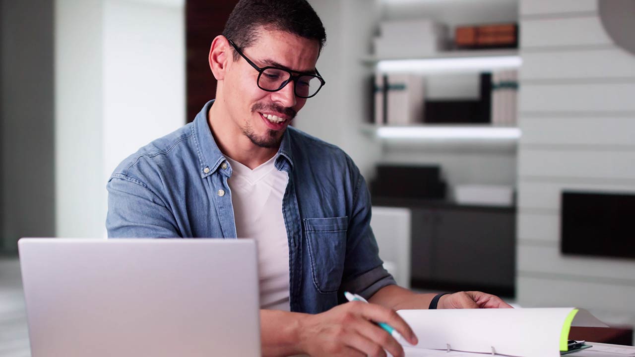 Estudiante de la licenciatura en banca y finanzas en línea revisa estadísticas en su laptop.