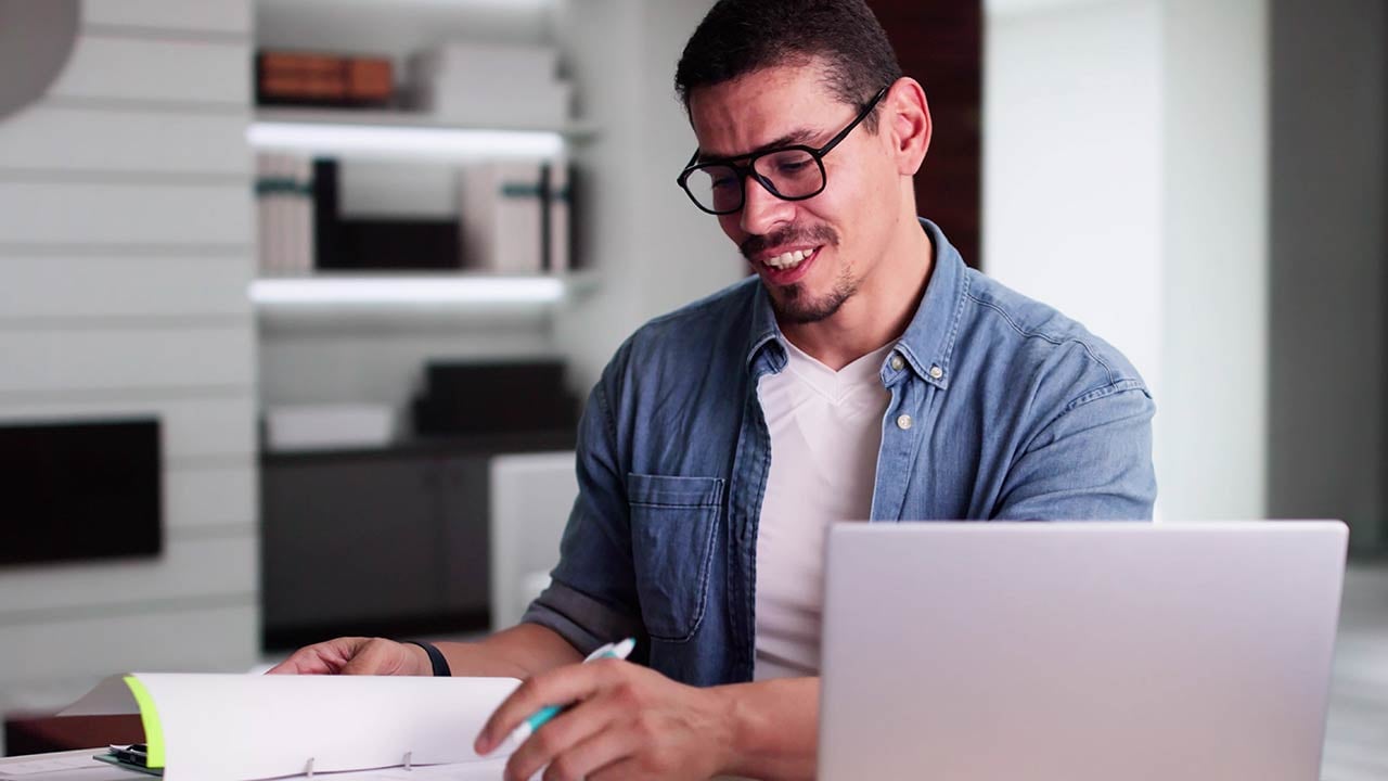 Estudiante de la licenciatura en banca y finanzas en línea revisa estadísticas en su laptop.
