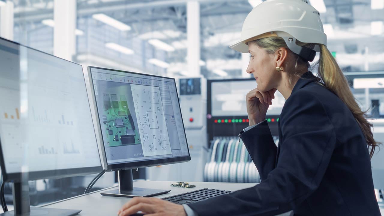 Mujer ingeniera en computadora revisando manufacturación