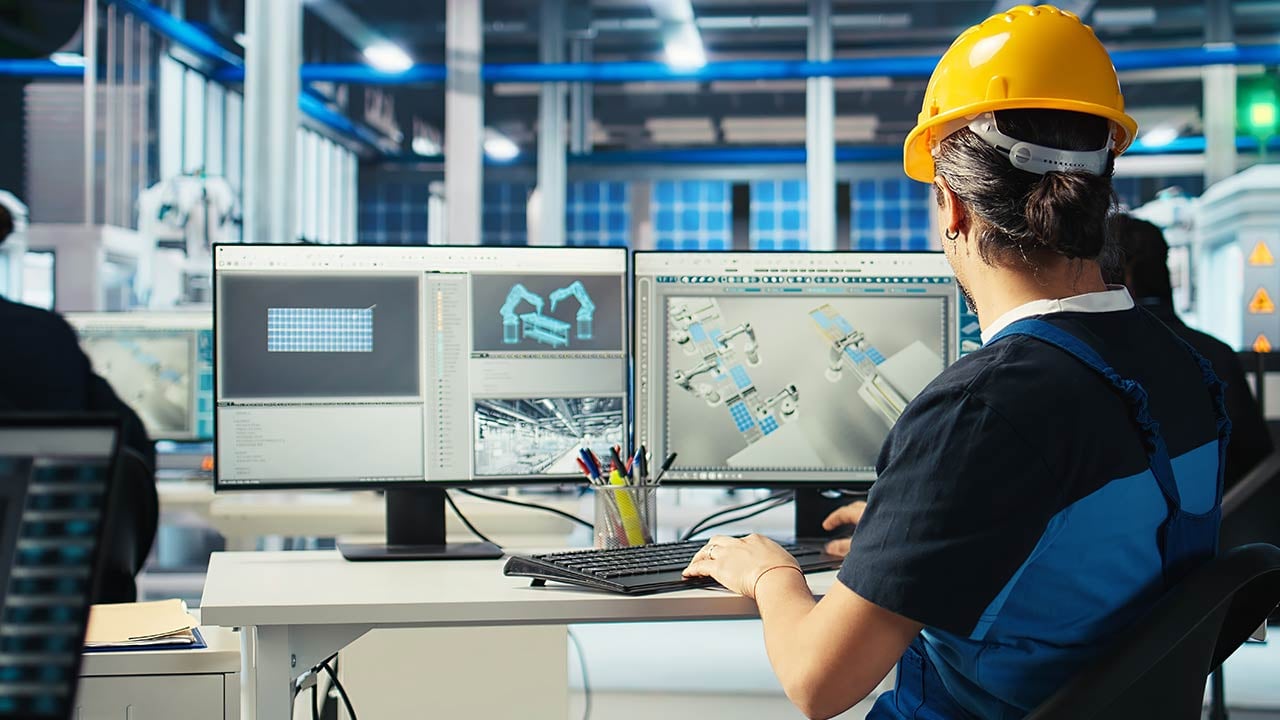 Ingeniera en Manufactura en escritorio revisando dispositivos de mantenimiento