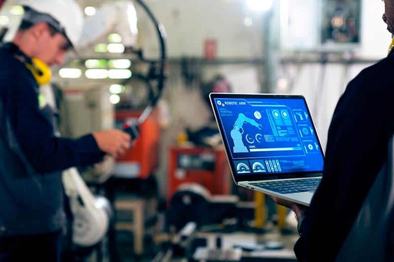 Ingenieros dando mantenimiento a robots de manufactura