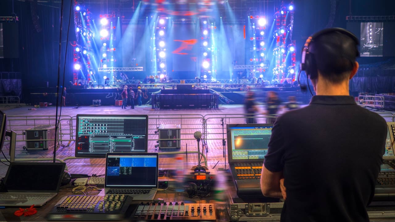 Estudiante de producción musical monitoreando concierto