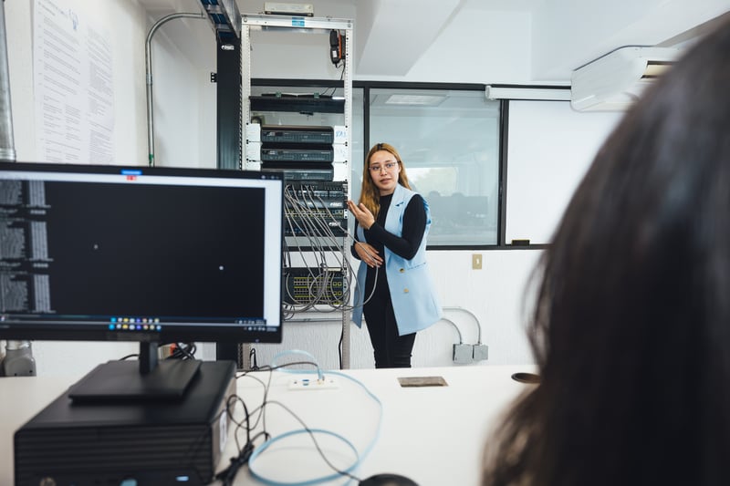Laboratorio CISCO UNITEC: docente explicando el rack de redes