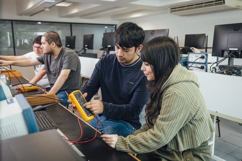 Laboratorio de electrónica UNITEC: alumnos midiendo con multímetro