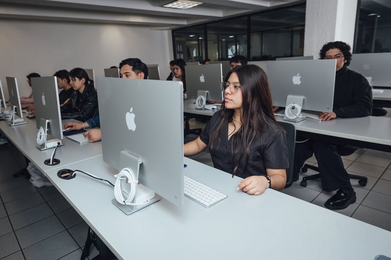 Laboratorio de cómputo y Mac UNITEC: alumna frente a un iMac