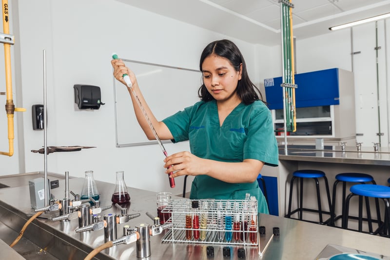 Laboratorio Multifuncional UNITEC: alumna pipeteando en el laboratorio