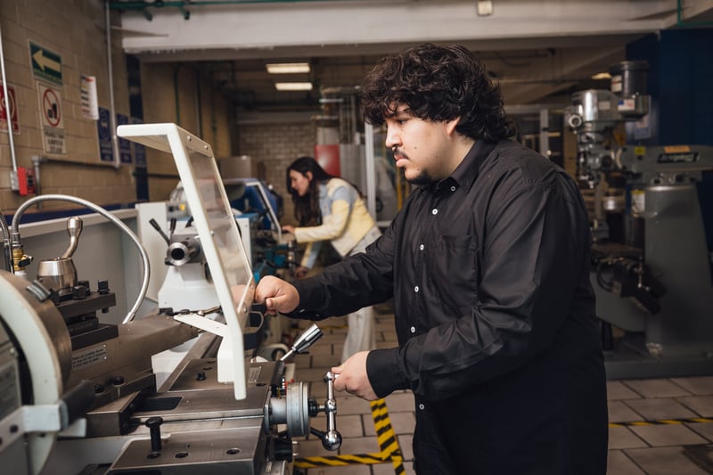 Laboratorio de manufactura UNITEC: alumno operando un torno