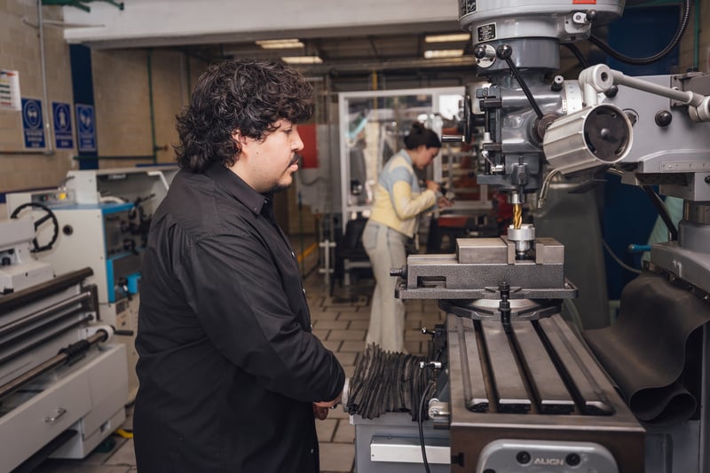 Laboratorio de manufactura UNITEC: alumno en una fresadora