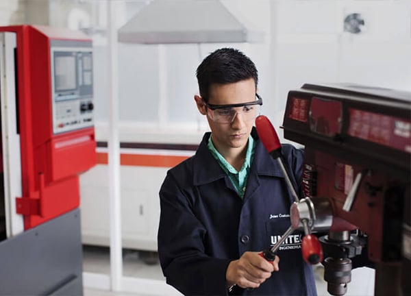 Laboratorio de máquinas y motores UNITEC: alumno en una fresadora