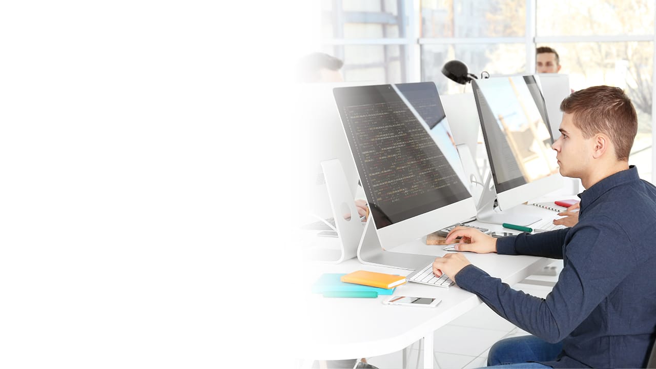 Alumno de Ingeniería en Desarrollo de Software frente a una computadora Mac revisando algoritmos.