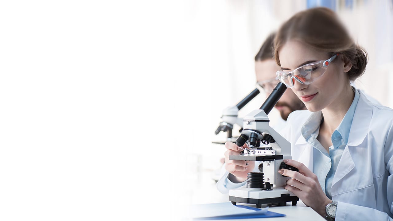 Alumnos de la carrera de química observando muestra en microscopio.