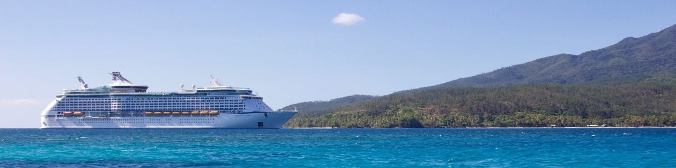 Crucero de lujo navegando en aguas tropicales con vista a una isla - Turismo sostenible en alta mar