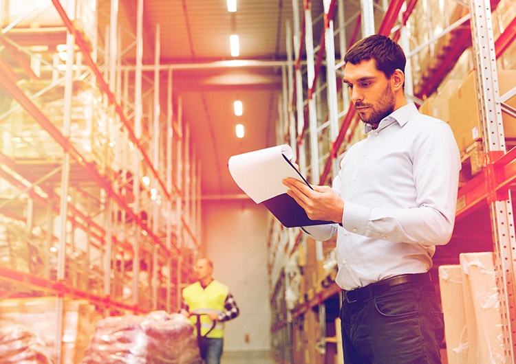 Profesional de Ingeniería Logística en una bodega revisando un listado